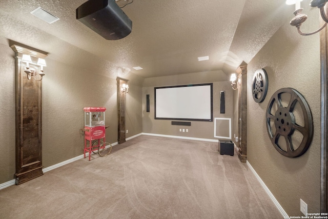 carpeted home theater room with a textured ceiling and lofted ceiling