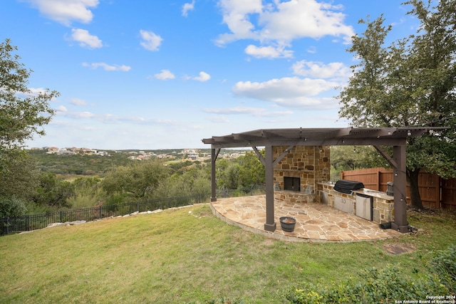 view of yard with a patio area, exterior kitchen, and an outdoor stone fireplace