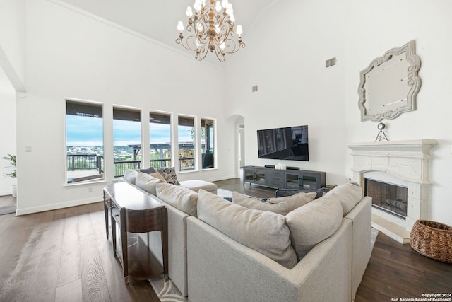 living room with dark hardwood / wood-style floors, a towering ceiling, and an inviting chandelier