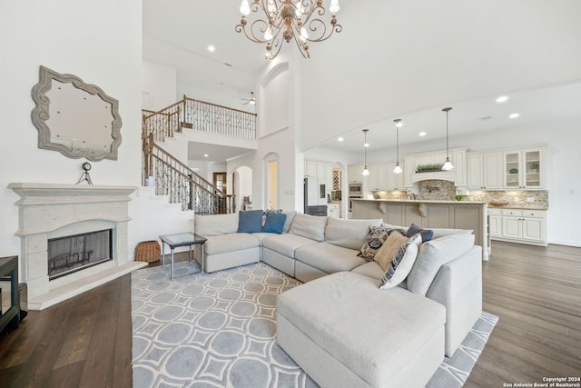 living room with a high ceiling, a notable chandelier, and hardwood / wood-style floors