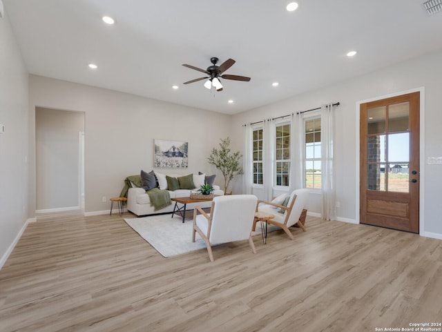 living room with ceiling fan and light hardwood / wood-style flooring