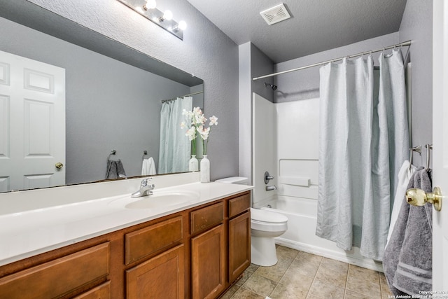 full bathroom with tile patterned floors, vanity, a textured ceiling, shower / bath combo with shower curtain, and toilet