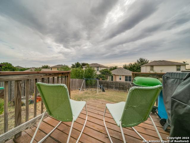 wooden deck with a playground and grilling area