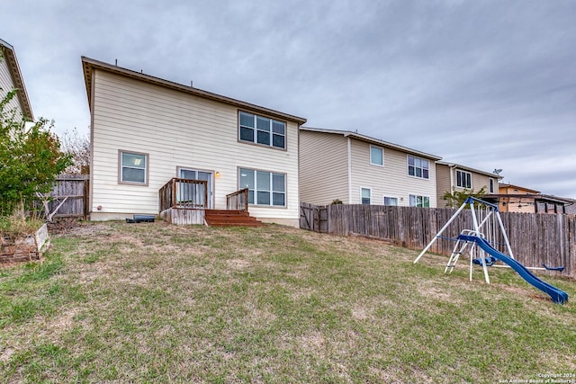 back of property featuring a playground and a lawn