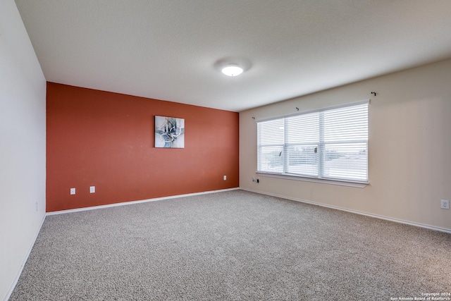 carpeted empty room featuring a textured ceiling