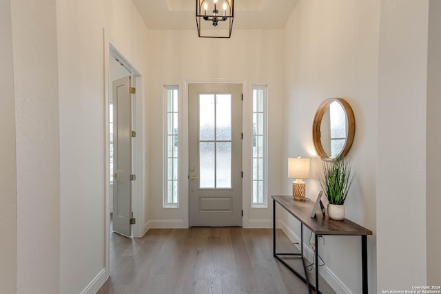 foyer featuring light wood-type flooring and an inviting chandelier