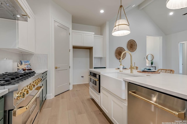 kitchen featuring custom range hood, appliances with stainless steel finishes, decorative light fixtures, light hardwood / wood-style floors, and white cabinetry