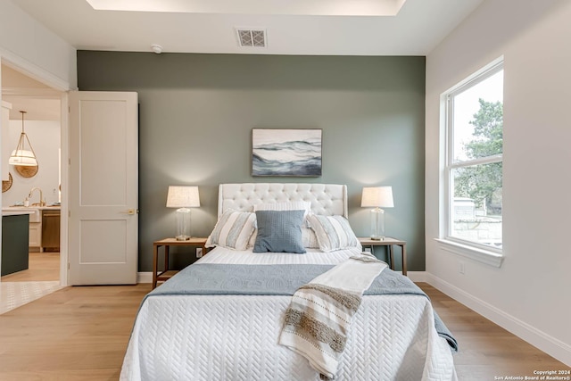 bedroom featuring light wood-type flooring and sink