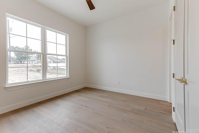 spare room featuring light hardwood / wood-style flooring, a wealth of natural light, and ceiling fan