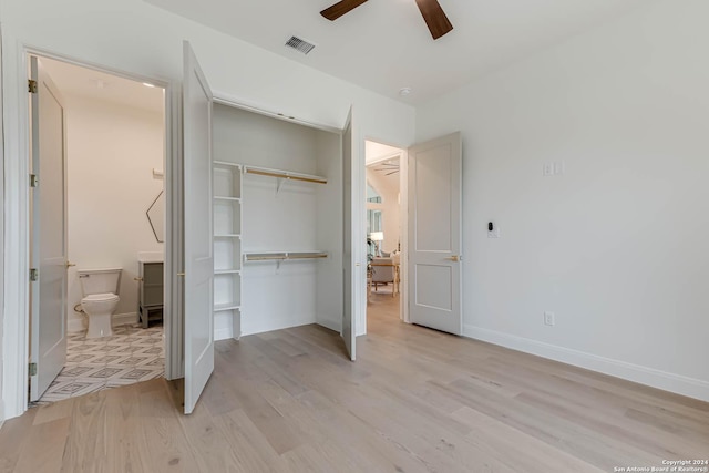 bedroom with ceiling fan, ensuite bathroom, light hardwood / wood-style flooring, and a closet