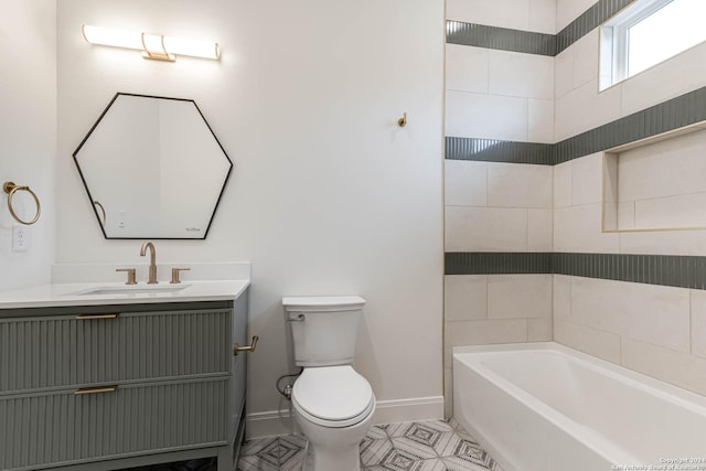 bathroom with a bathing tub, vanity, toilet, and tile patterned floors