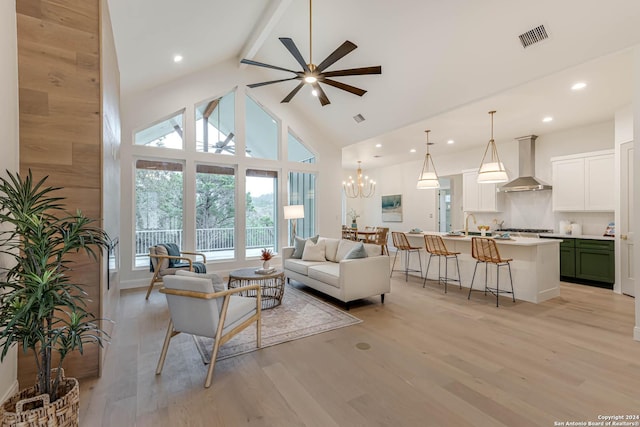 living room featuring beamed ceiling, ceiling fan with notable chandelier, high vaulted ceiling, and light hardwood / wood-style flooring