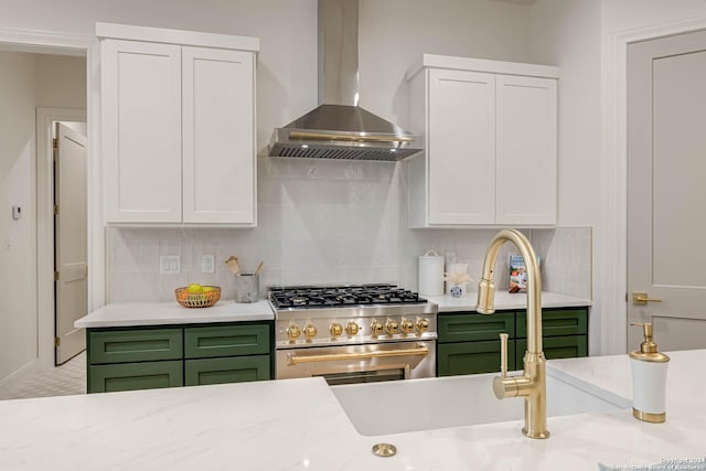 kitchen with white cabinets, green cabinetry, high end stainless steel range, and wall chimney range hood