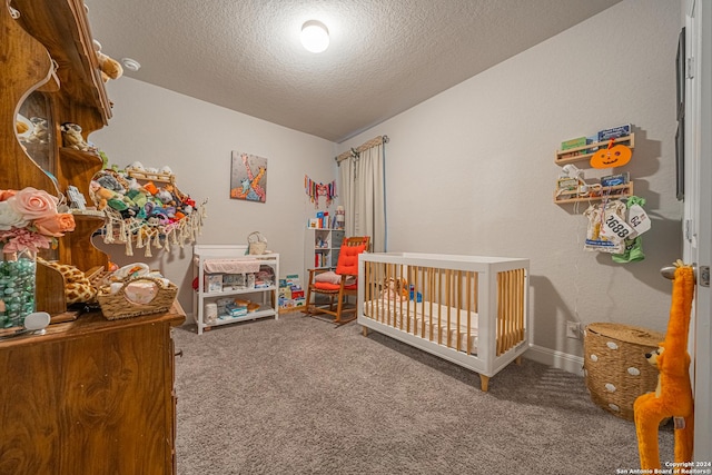 carpeted bedroom featuring a textured ceiling and a crib