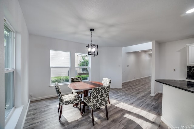 dining space featuring hardwood / wood-style floors and an inviting chandelier