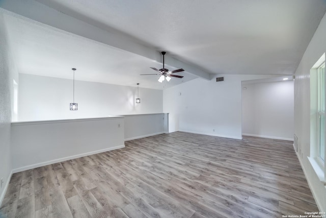 empty room featuring vaulted ceiling with beams, ceiling fan, and light wood-type flooring