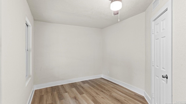 spare room with light hardwood / wood-style floors and a textured ceiling