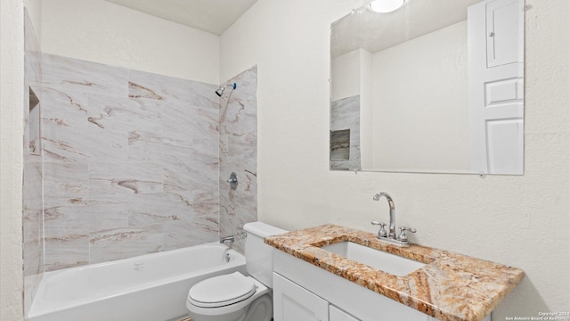 full bathroom featuring vanity, tiled shower / bath combo, and toilet