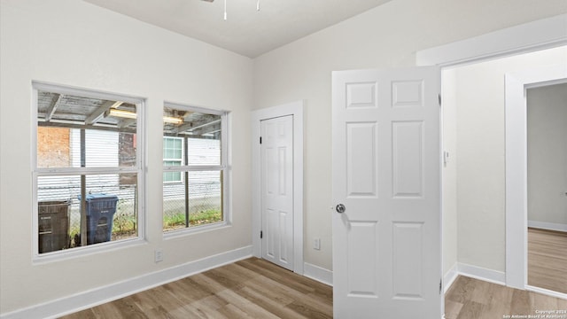 unfurnished room with vaulted ceiling and light hardwood / wood-style flooring