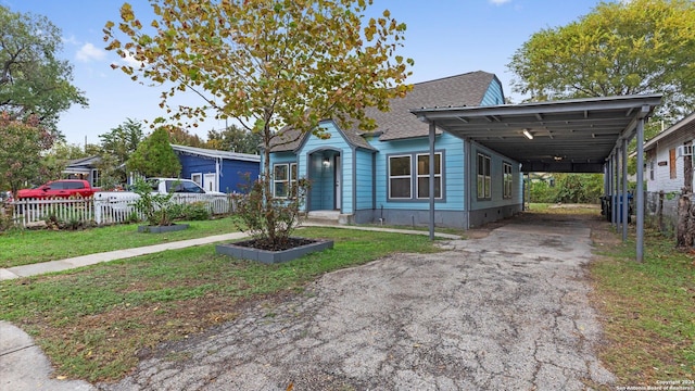 view of front of house with a carport and a front lawn