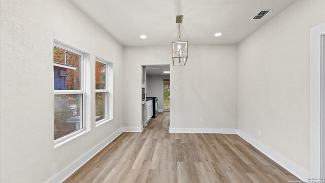 unfurnished dining area featuring light wood-type flooring