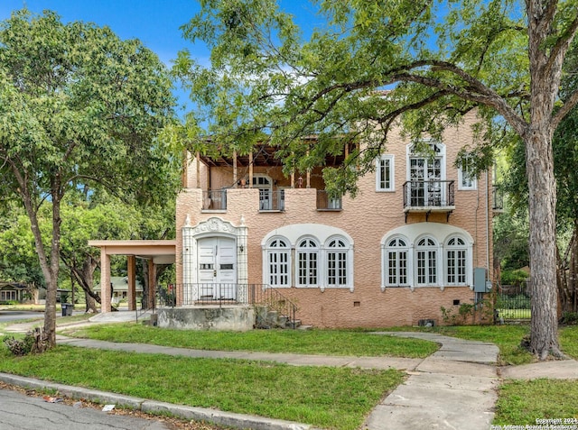 view of front of home featuring a balcony and a front yard