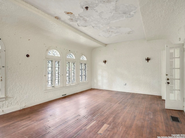 interior space featuring a textured ceiling, hardwood / wood-style flooring, and vaulted ceiling