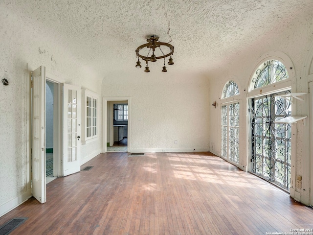 spare room featuring wood-type flooring and a textured ceiling