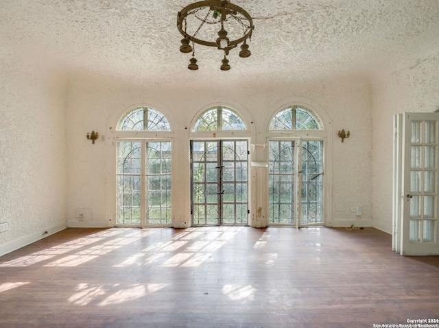 interior space with a wealth of natural light, a textured ceiling, and light wood-type flooring