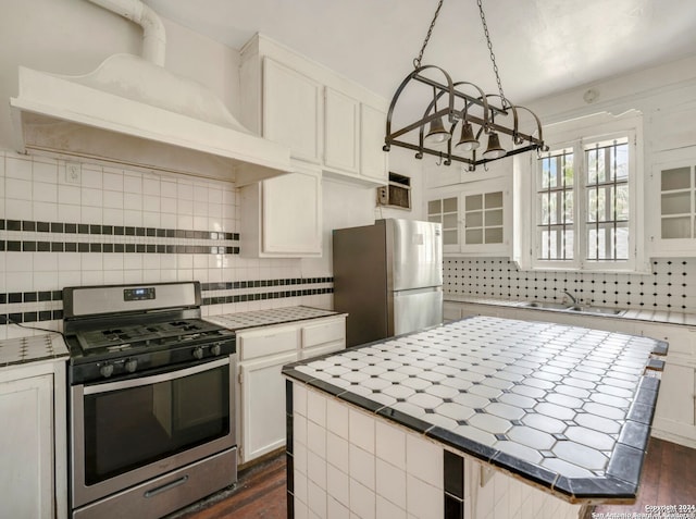 kitchen featuring dark hardwood / wood-style flooring, a center island, stainless steel appliances, and white cabinetry