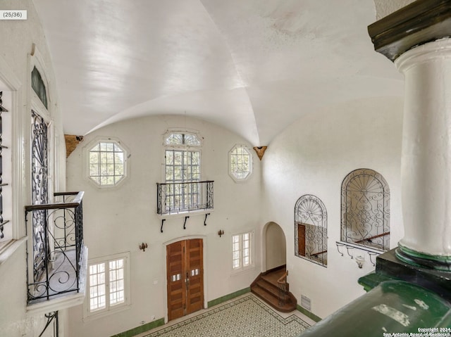 foyer featuring decorative columns and lofted ceiling