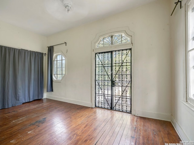 unfurnished room with a barn door and dark hardwood / wood-style floors