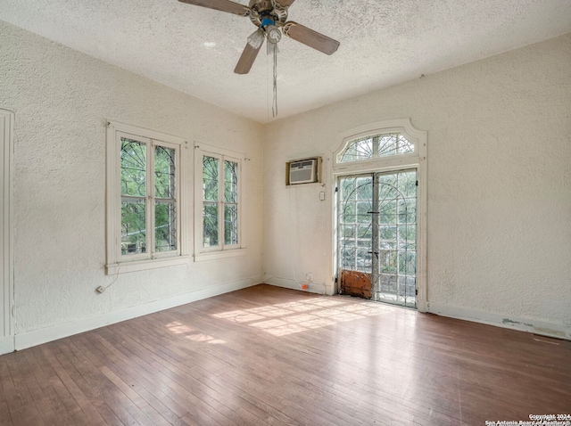 spare room featuring a wealth of natural light, ceiling fan, a textured ceiling, and hardwood / wood-style flooring