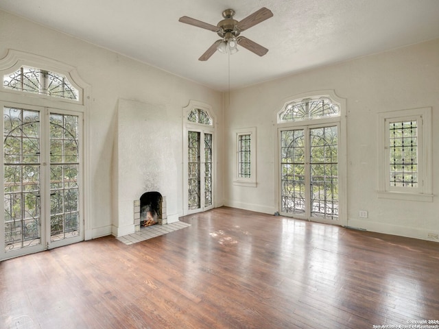 unfurnished living room featuring a fireplace, hardwood / wood-style floors, and ceiling fan