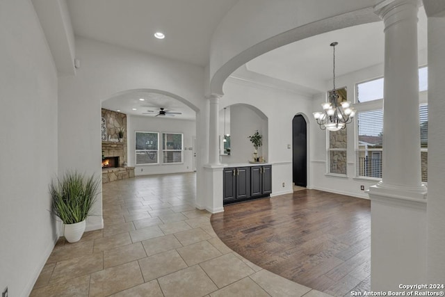 interior space with ceiling fan with notable chandelier, light hardwood / wood-style floors, and a fireplace