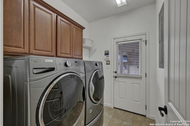 laundry room featuring cabinets, light tile patterned floors, and washing machine and dryer