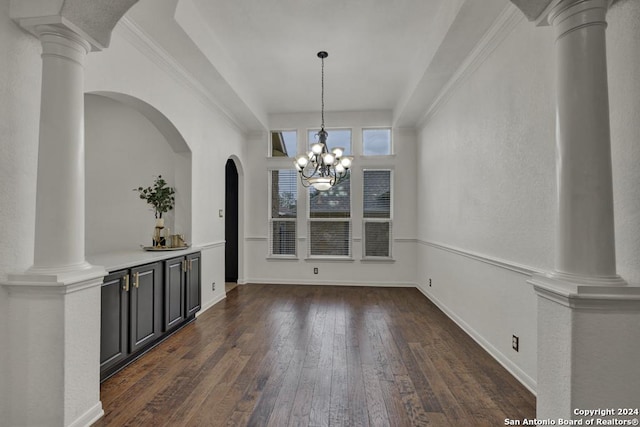 unfurnished dining area with crown molding, dark wood-type flooring, and an inviting chandelier