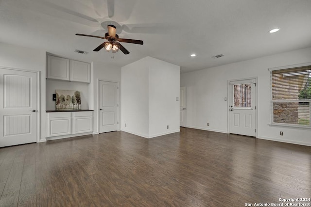 unfurnished living room featuring dark hardwood / wood-style floors and ceiling fan