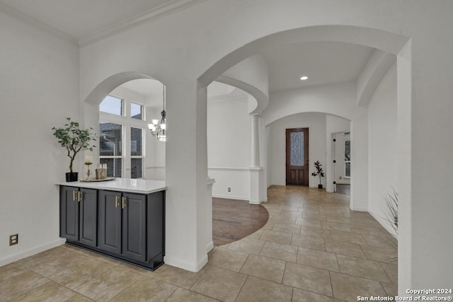 interior space featuring crown molding, light tile patterned floors, and an inviting chandelier