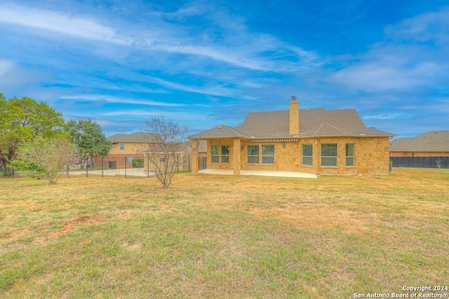 back of house with a lawn and a patio area