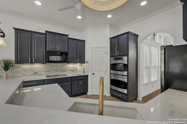 kitchen featuring ceiling fan, tasteful backsplash, light wood-type flooring, black appliances, and ornamental molding