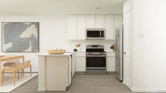 kitchen with white cabinetry, stainless steel appliances, and light hardwood / wood-style flooring