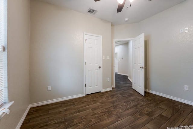 unfurnished bedroom featuring ceiling fan and dark wood-type flooring