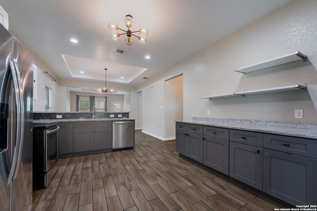 kitchen featuring gray cabinetry, dark hardwood / wood-style flooring, a notable chandelier, and appliances with stainless steel finishes