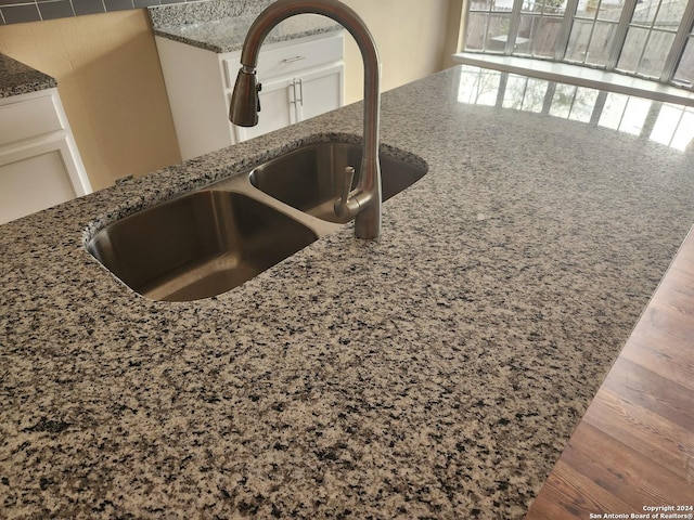 room details featuring dark hardwood / wood-style floors, dark stone counters, and sink