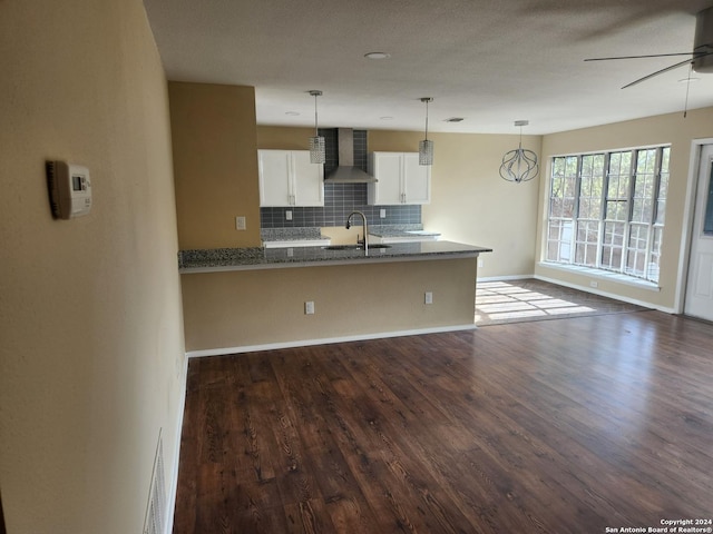 kitchen featuring sink, wall chimney exhaust hood, tasteful backsplash, dark hardwood / wood-style floors, and white cabinets