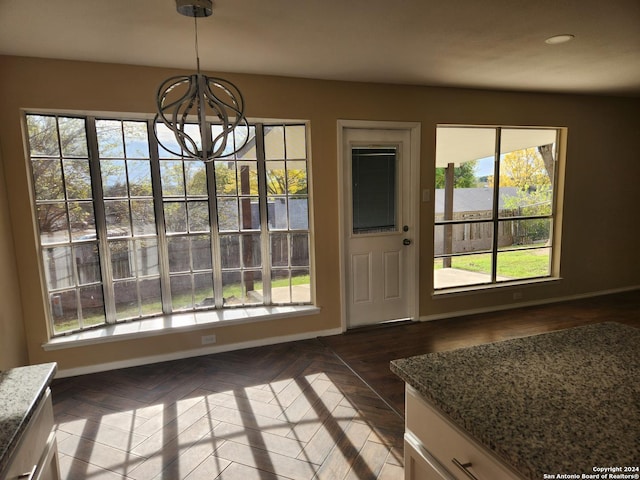 doorway to outside featuring an inviting chandelier and dark wood-type flooring