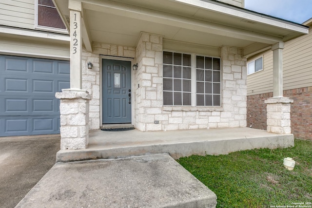 view of exterior entry featuring a porch and a garage