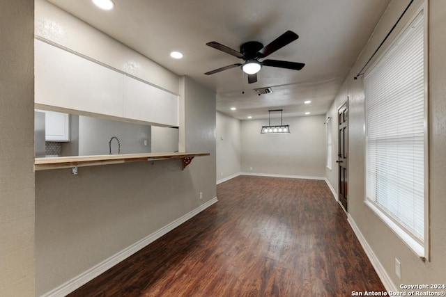 spare room with ceiling fan, sink, and dark wood-type flooring