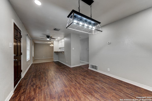 unfurnished living room with ceiling fan and dark hardwood / wood-style flooring